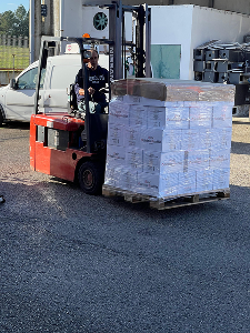An electric car carries a pallet of beer